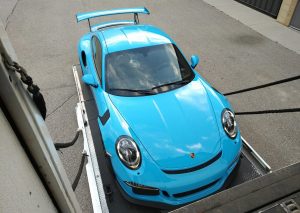 Miami Blue Porsche GT3RS loading onto enclosed lift gate transporter for our gallery